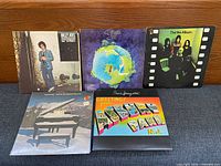 Five vinyl LP record sleeves arranged front facing