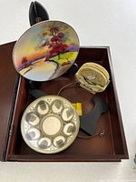 Interior view showing plate, bowl, soapstone trivets, stands inside memory box