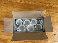 Six bubble-wrapped porcelain mugs inside shipping box