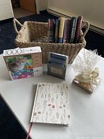Overview of basket with books, puzzle, notebook, stationery set, tea lights