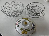 Porcelain casserole lid and base with gold knob, chrome circular ring bowl, chrome spiral bowl