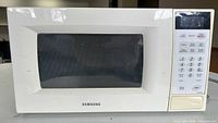 Front view of Samsung microwave showing window, control panel and wear