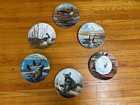 Six wildlife ceramic plates arranged on wooden floor