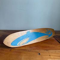 Side view showing blue shark graphic on wooden deck