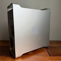 Left-rear three-quarter view showing aluminium housing, side panel scratches, and rear I/O area