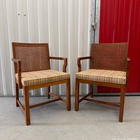 Front three-quarter view of both chairs showing cane backs and cushions