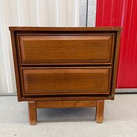 Front view of walnut two-drawer nightstand showing overall design and finish