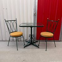 Full patio set showing two chairs and glass-top table