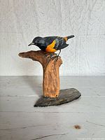 Front view of carved Baltimore Oriole on branch base