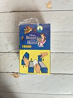 Front of sealed Panini sticker box showing Belle & Beast artwork and album stickers label