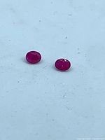 Both oval rubies side by side on white background