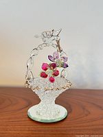 Full view of clear glass hummingbird basket figurine on mirrored base