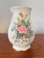 Front view of white bud vase showing floral design and shape