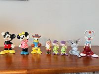 Group shot of all eight porcelain Disney figurines on shelf