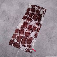 Full view of brown and tan silk scarf laid flat