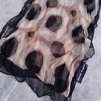 Close-up of scarf fabric showing black and beige polka dots