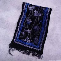 Full view of folded black and blue floral silk scarf with fringe
