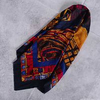 Folded scarf showing abstract design in black, blue, red and gold