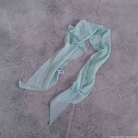 Full view of light blue scarf laid flat on floor