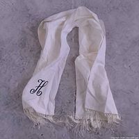 Full view of white rayon scarf with fringe and H monogram