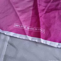 Close-up of corner showing 100% Silk Made in Italy text and white rolled hem