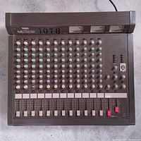 Top view of Yamaha MC1202 mixer showing all 12 channels, faders, VU meters and overall condition