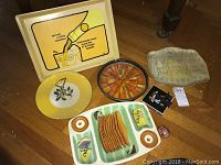 Wide shot showing all items in the lot including trays, plates, ashtray, bottle opener, and small items.
