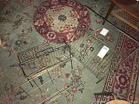 Three vintage wired magazine racks laid on a colorful patterned rug, showing different designs and sizes.