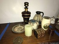 Image showing all items grouped together on wooden surface, including bronze medal, candlestick, trinket boxes, vases, and plate.