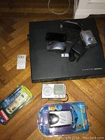 Photo showing Panasonic electronic typewriter, Samsung Galaxy S cell phone, Coby radios, Fujifilm camera, and various computer accessories including USB adapter and mouse.