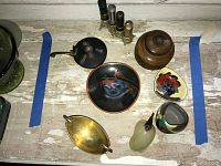 Overview of vintage decorative items including multi-slot lipstick holder with lipsticks, lacquered bowl with bird motif, wooden trinket box, colorful vase, green glass object, and small decorative bowls.