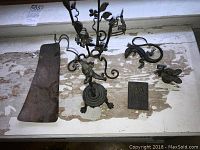 Overhead view of all the bronze items including the Mercury figure, lizard figurine, floral holder, and copper plate