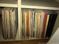 Shelf with a collection of classical music vinyl records in sleeves and album covers, showing composers like Beethoven, Toscanini, Tchaikovsky