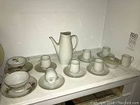 Full view of tea set with 6 cups and saucers, teapot, creamer, sugar bowl, and 2 additional floral cups and saucers