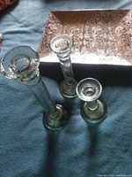 Three green glass candle holders with silver patterned tray