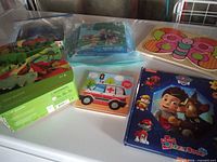 Group of six assorted children’s puzzles on table