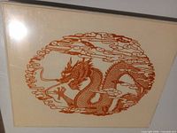Front view showing full red dragon papercut on cream backing