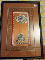 Full view of framed embroidery showing peonies, mat, and frame