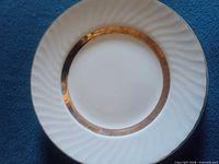 Front view of single plate showing gold band and fluted rim