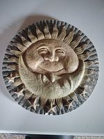 Front of celestial round plaque showing design and surface condition