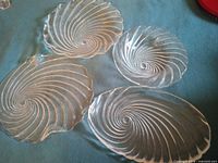 Four spiral clear glass plates on a surface