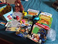 All items laid out: ear defenders, books, toys, bucket, bear, storage case