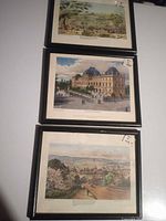 Three of the framed prints stacked: top unknown scene, middle Parliament House Brisbane, bottom Parramatta NSW, showing black frames and white mats