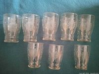 Eight etched floral glasses displayed on cloth, showing two sizes