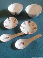 Full lot showing 2 bowls, 2 saucers, 2 spoons with ping pong motif