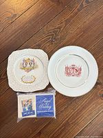 Front view of both commemorative plates and sealed matchbook pack