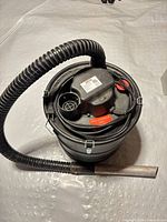 Top view of ash vacuum showing motor housing, hose connection and coiled power cord