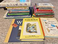 Front view showing stacks of children’s books with prominent Winnie-the-Pooh, Beatrix Potter and other titles