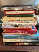 Stack of twelve cookbooks showing spines and formats