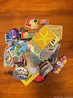 Pile of assorted travel and novelty magnets on wooden surface